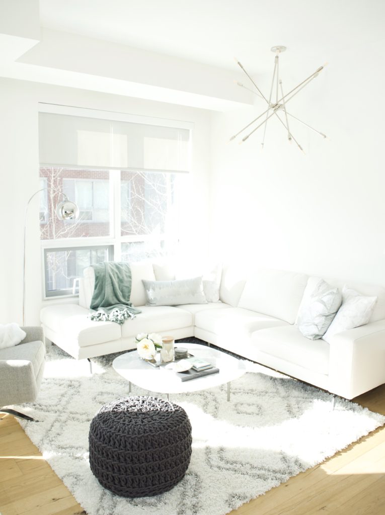 modern scandinavian scandi glam white grey black ivory concrete pillar design swivel chair sectional silver decor living room apartment small space marble table white leather sectional seafoam green pastel soft bright white paint calgary interior designer home by freya maclean pouf ottoman knit modern Scandinavian condo apartment light bright white soft clean