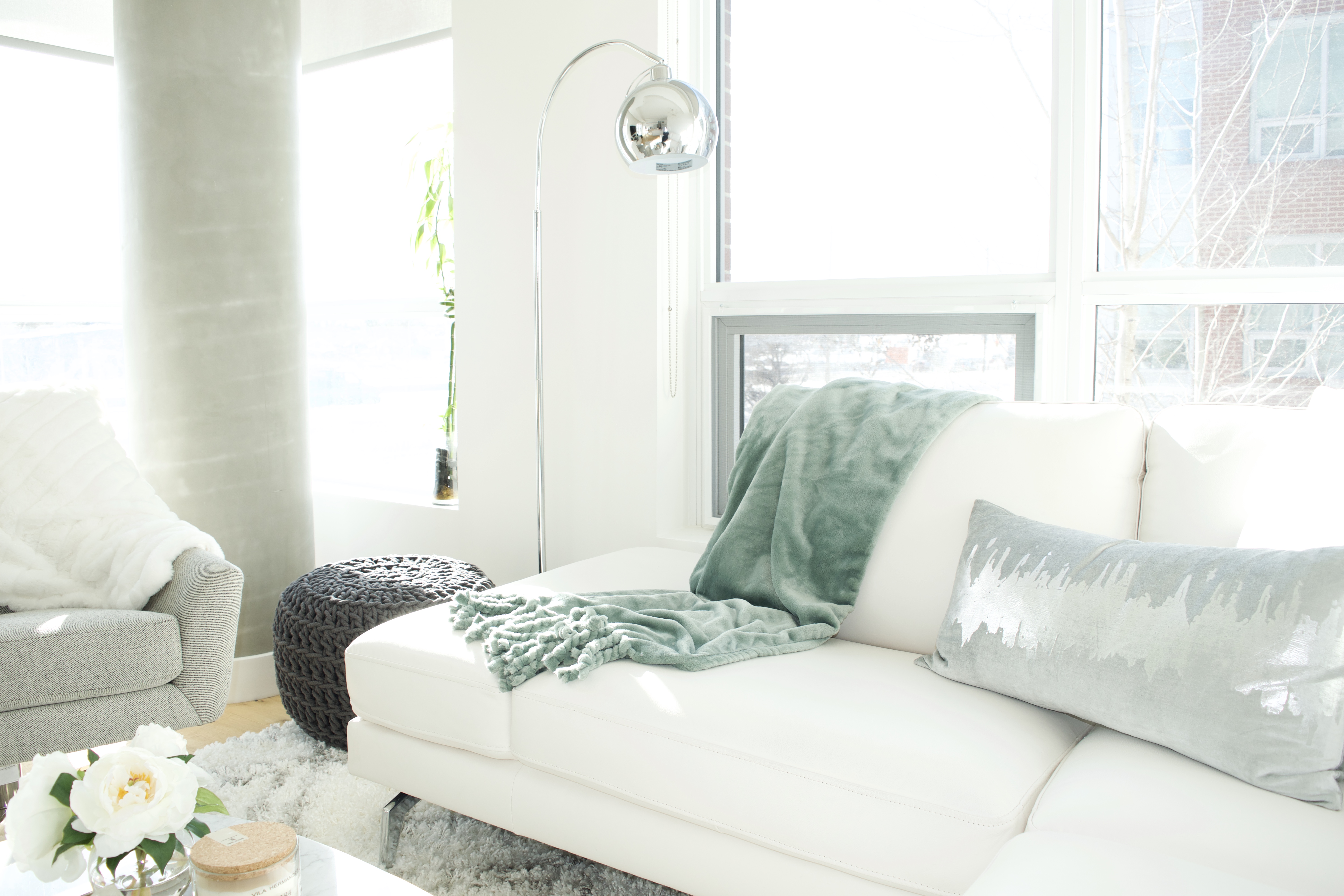 modern scandinavian scandi glam white grey black ivory concrete pillar design swivel chair sectional silver decor living room apartment small space marble table white leather sectional seafoam green pastel soft bright white paint calgary interior designer home by freya maclean pouf ottoman knit arc lamp leather couch corner pillows tassel blanket