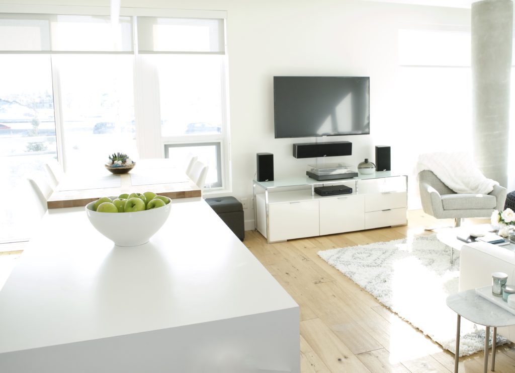 open concept living room kitchen modern apartment calgary inner city interior design tv oak floors white black grey windows high ceilings