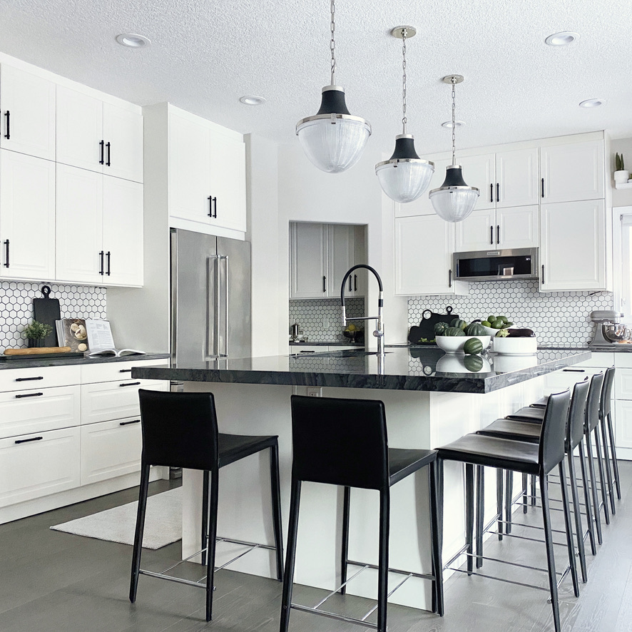 Calgary interior design and real estate staging services - black and white family kitchen white cabinets nickel quartzite counters pendant lights oversized island grey family kitchen renovation design ideas