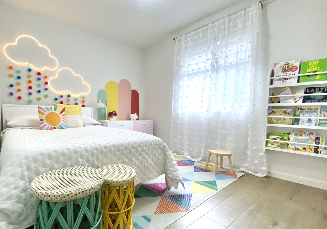 Modern colourful minimal kids boys girls bedroom room double bed pink ikea stuva smastad rainbow multicolour color pop rainbow cloud LED neon light sign meraki wall decal arches ruggable Ziggy sunshine red orange yellow green blue purple white walls pottery barn white wood bed wall mount forward facing book display bookcase pom pom curtains sheer girly