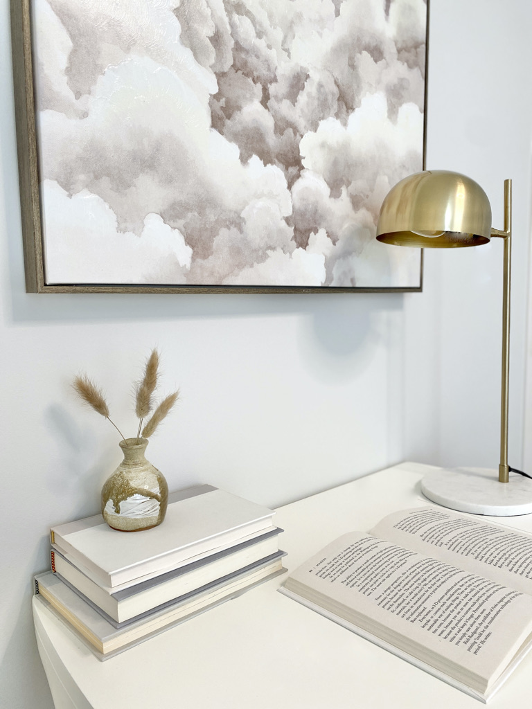 styled office desk guest room bedroom workspace brass lamp books neutral art white light beige taupe