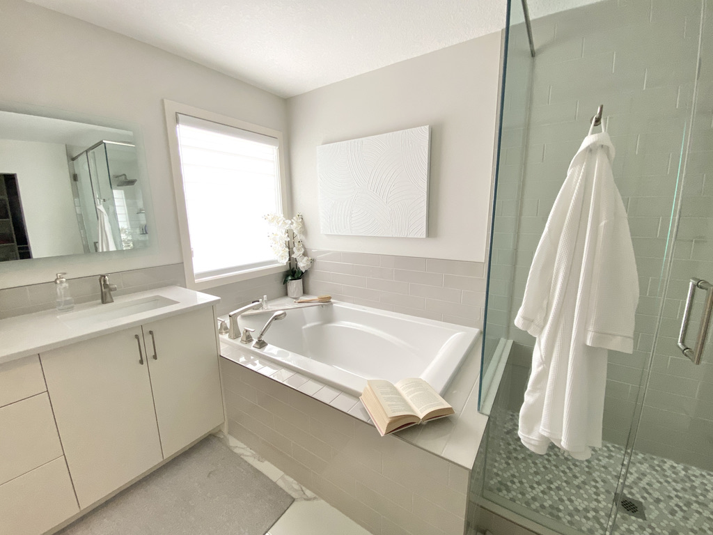 ensuite bathroom minimal simple space soft white grey beige ivory built in tub white wall art robe bathtub glassed in shower mosaic floor subway wall