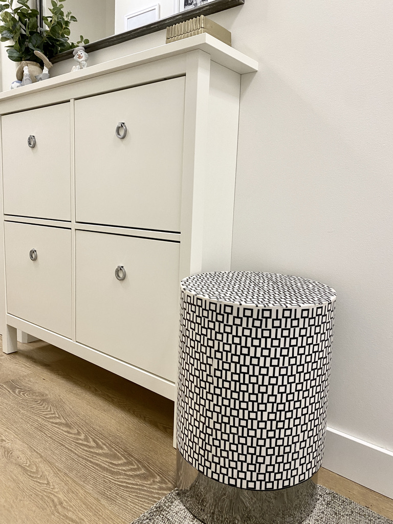 hemnes shoe cabinet white with replacment silver chrom ring pull hardware knobs, black and white bone inlay accent garden stool ottoman, geometric pattern stool, entry foryer design for a small space, wood floors, black and white, hallway, narrow cabinet in a hall with antique mirror